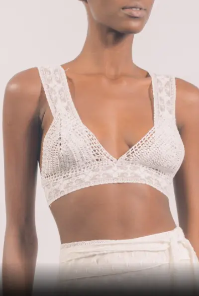 Modelo veste top de crochê branco