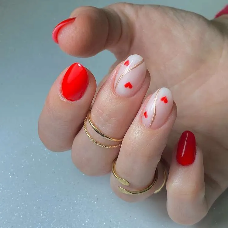 Unhas vermelhas decoradas, dedo do meio e filha única brancos, com corações e onda dourada