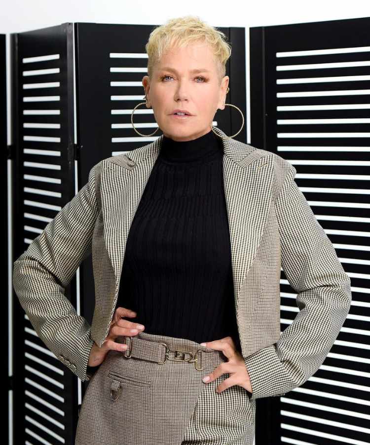 Foto de Xuxa com look xadrez preto e branco, usando brincos de argola.