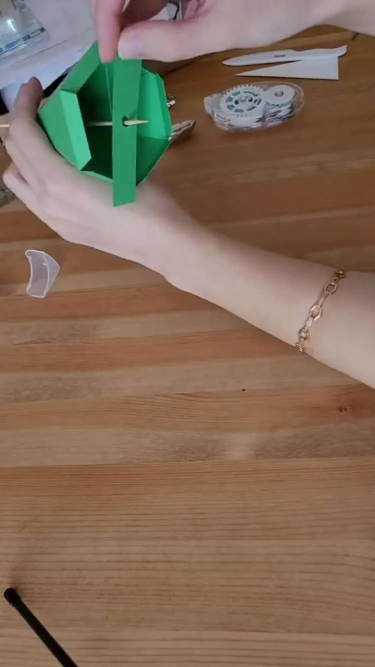 Colocando um pedaço de papel no meio das partes dos prismas do passo a passo de prisma para tiara de Halloween