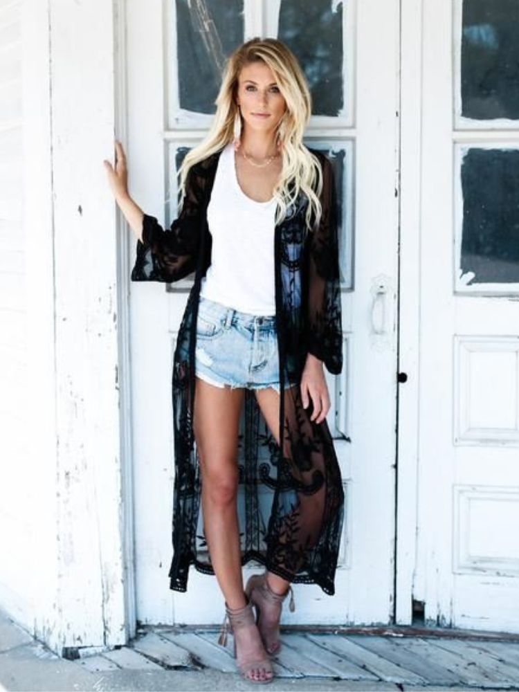 Mulher de pele clara com regata branca, kimono transparente e shorts jeans