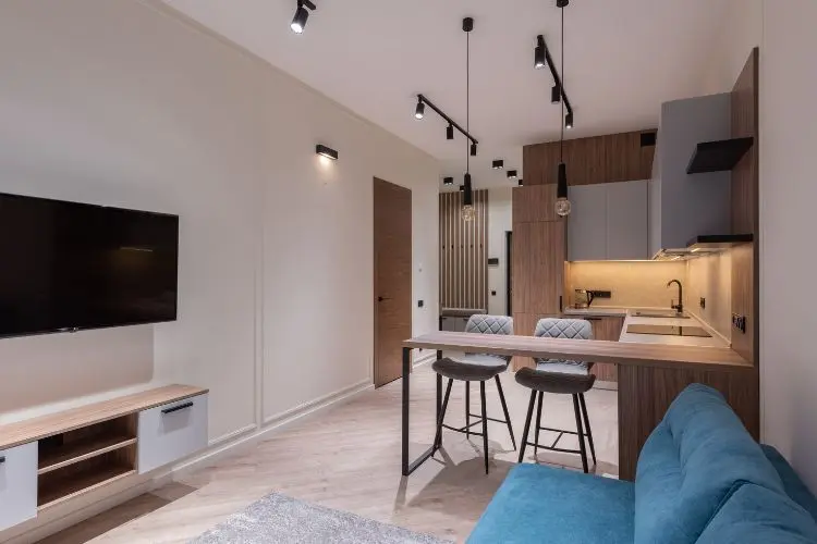Sala dois ambientes moderna, com luminárias retas, móveis com metais, madeira e mais