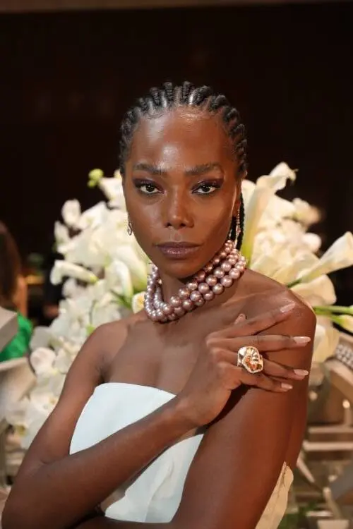 Jessica Cores usando colar de pérolas da Cris Porto e anel, vestido tomara que caia branco em fundo de flores brancas naturais