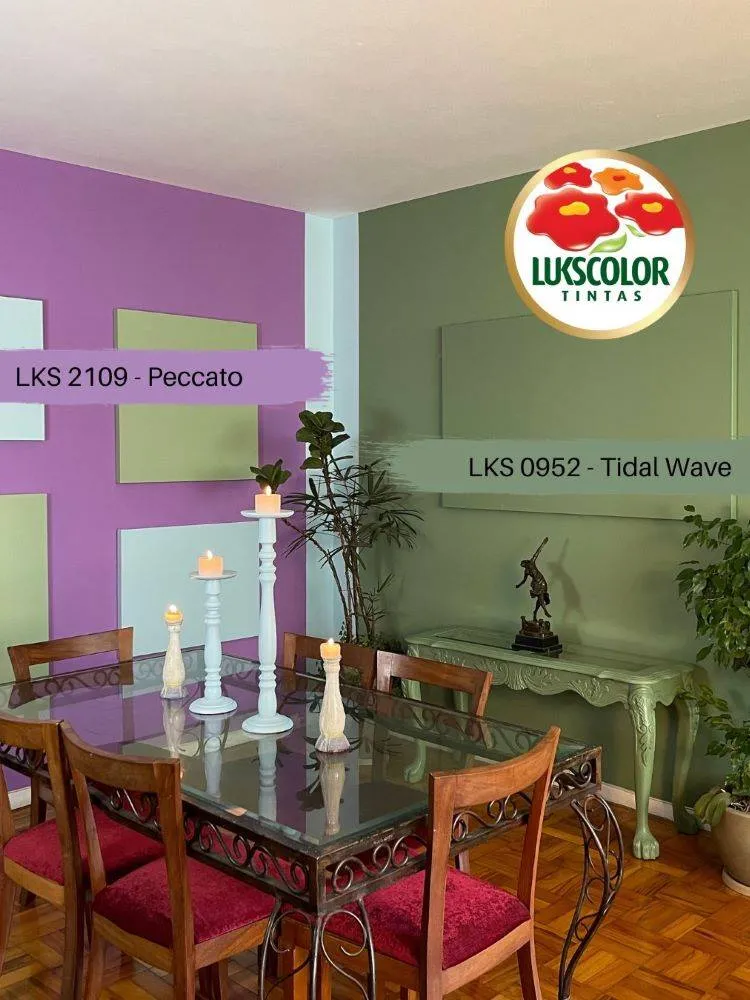 Sala de jantar com mesa de vidro e cadeiras de madeira, cuja parede é roxa e a outra em verde Tidal Wave. 