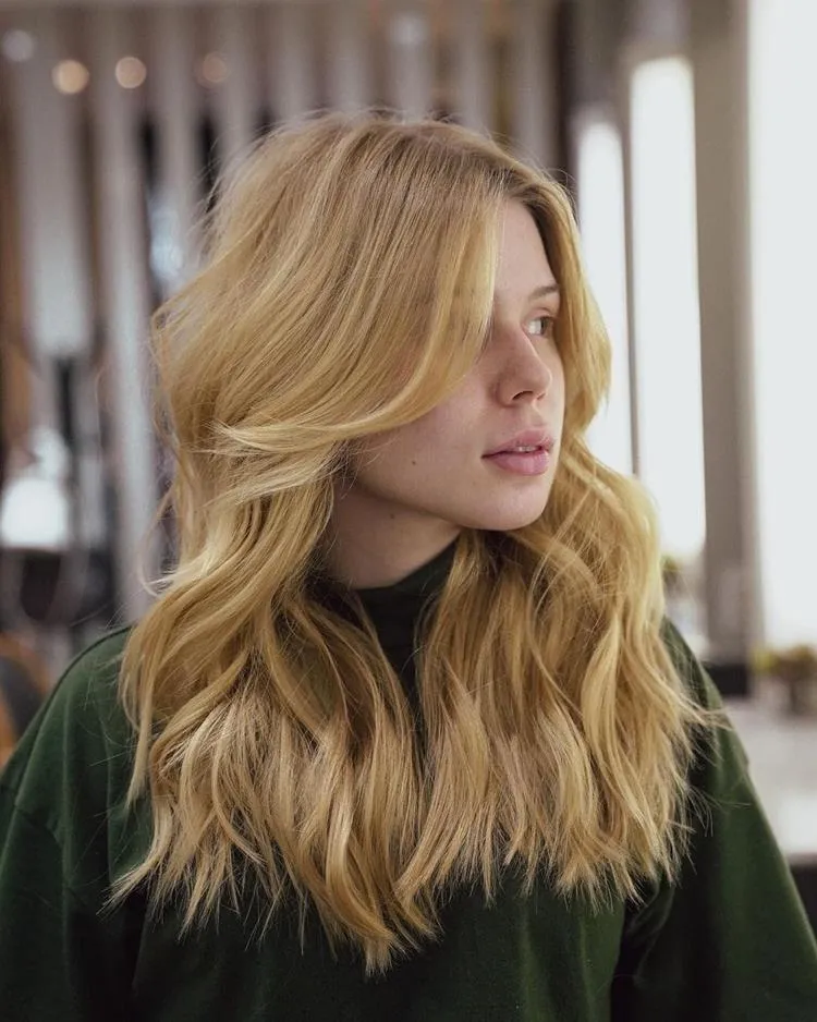 mulher loira com cabelo médio e franja cortina 
