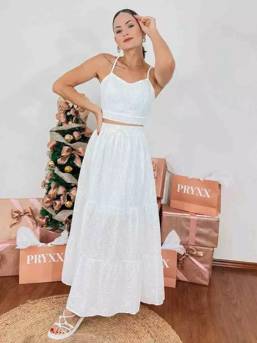 Mulher com look para o Réveillon: conjunto de top + saia longa brancos.