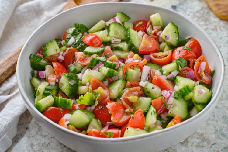 Foto de salada de pepino com tomate, cebola e temperos em bowl branco 