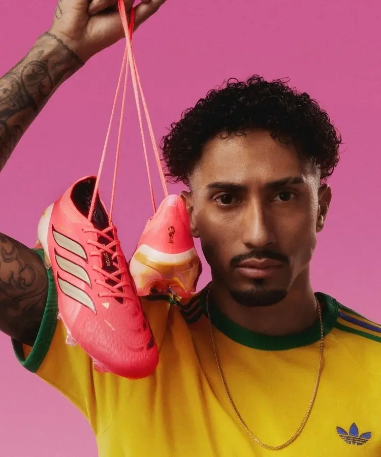 Raphinha segurando chuteira rosa da Adidas na Copa