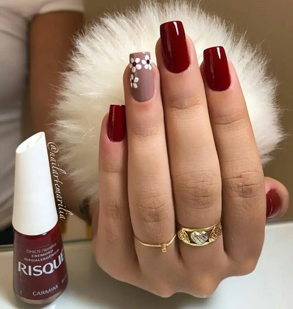 Simples vermelho escuro com flores no dedo anelar em nude.